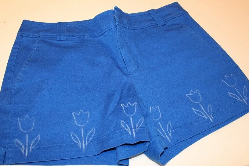 Take some plain shorts made from fabric without any print. Draw with a sewing marker few flowers like this.