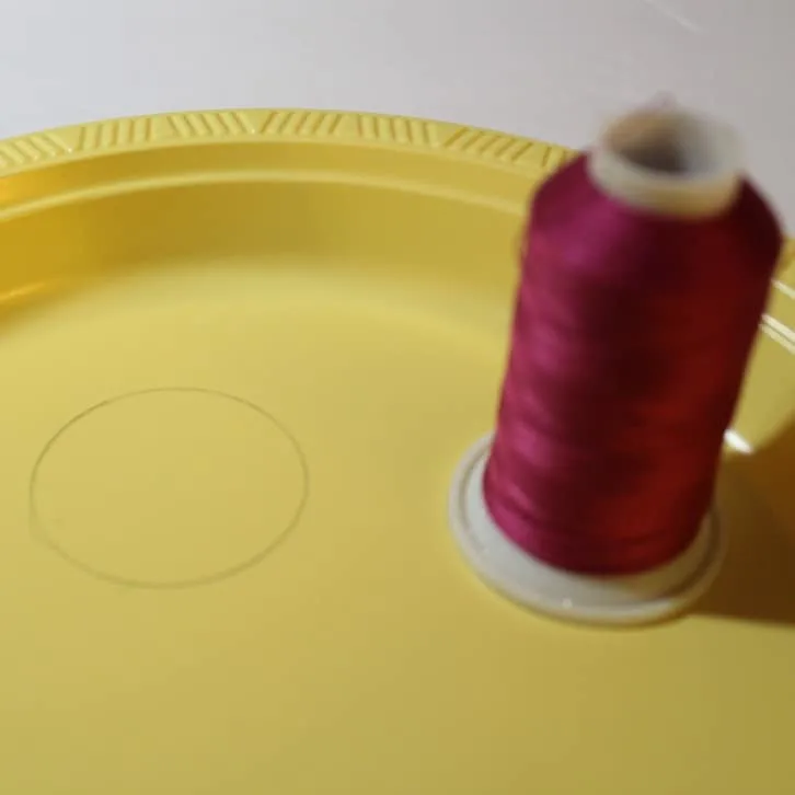Cut a small circle from a plastic plate for the pincushion