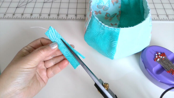 Fold the tab piece in half lengthwise and make a stitch