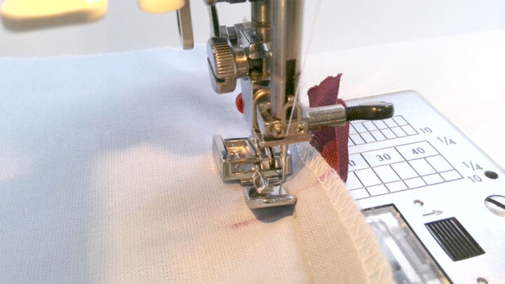 put your garment down on the machine and make a stitch that goes as close to the zipper stitches as possible