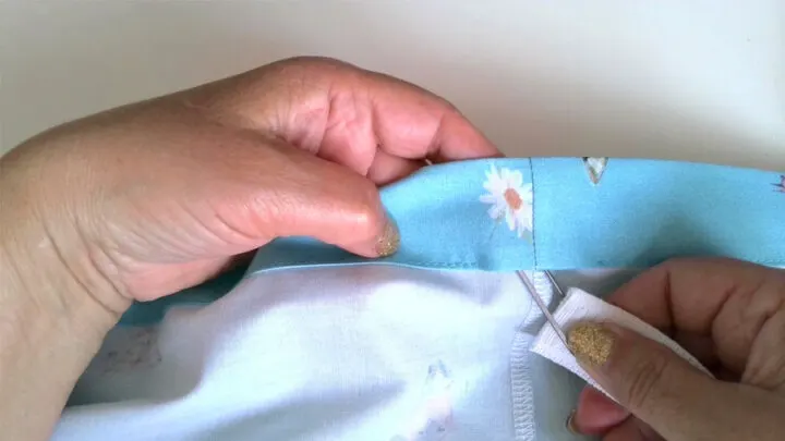 Thread a safety pin through one end of the elastic and then feed it through the casing