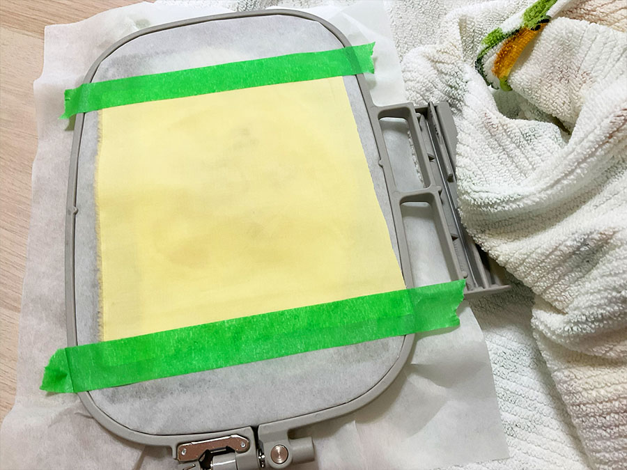 place a piece of fabric on the design. Secure it with tape