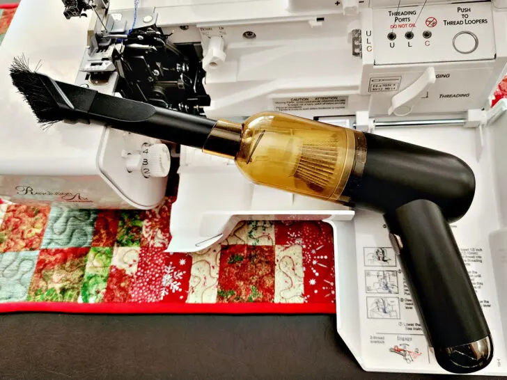 using a mini vaccum cleaner to clean my serger