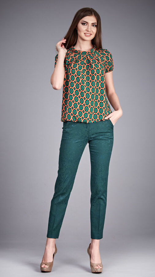 brown patterned top with green pants