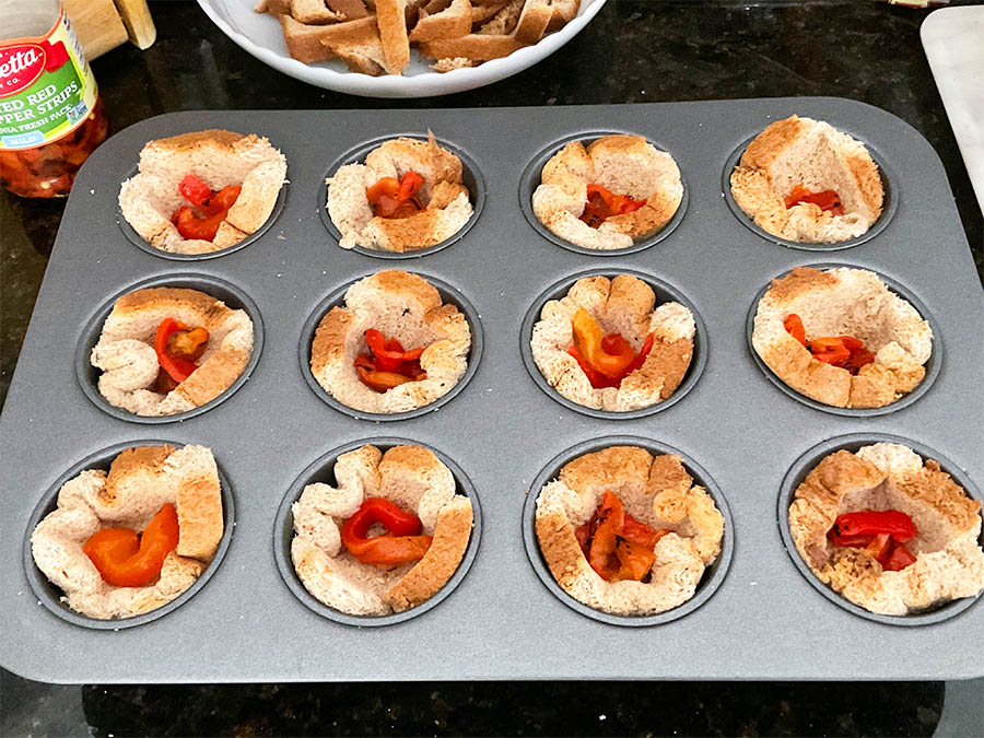 sliced bread with marinated roasted pepper on a muffin pan