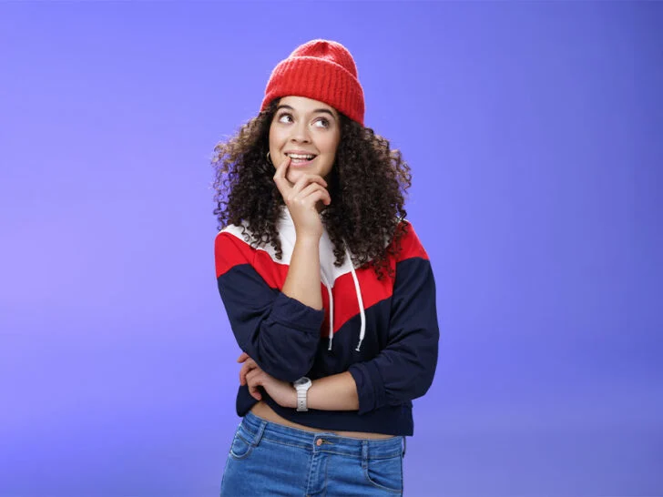 curly haired woman wearing a beanie