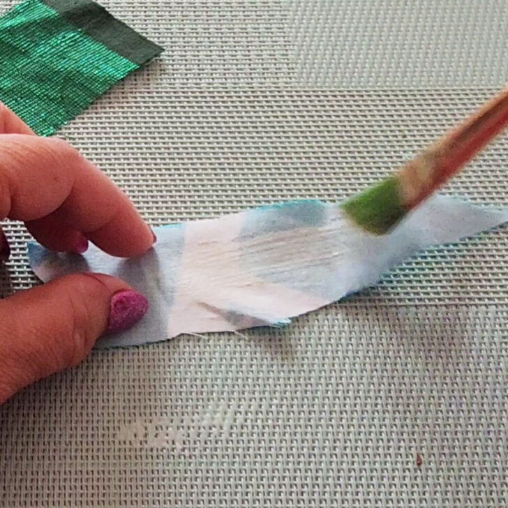 me applying fabric glue to a knitted fabric
