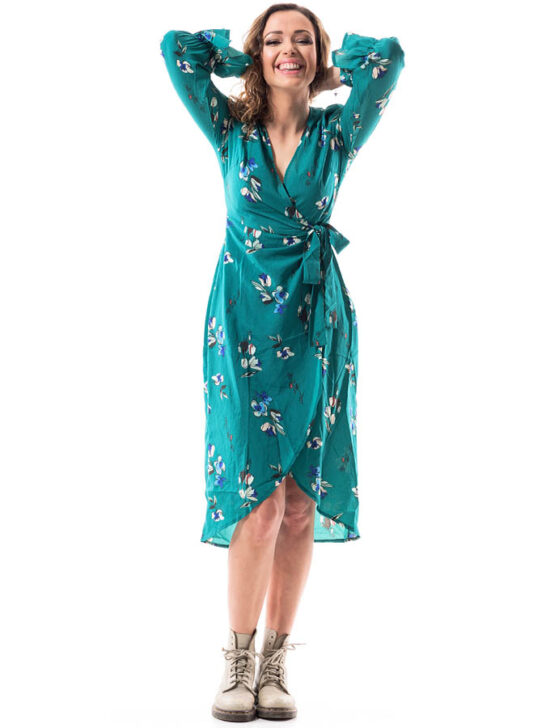 woman wearing a blue green wrap dress and boots