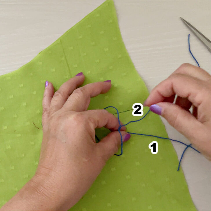 With your thumb and index finger already inserted into the loop from above, use them to grasp thread end 1.