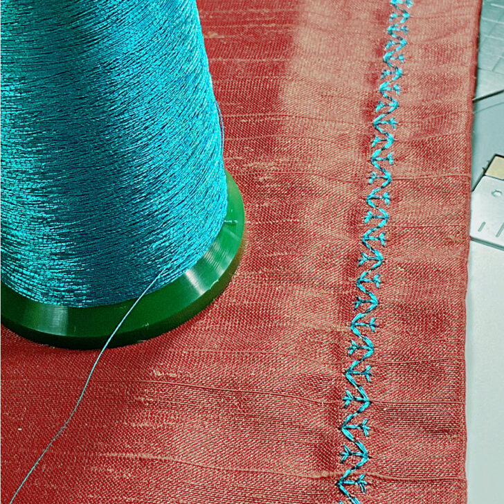 blue metallic thread on red fabric