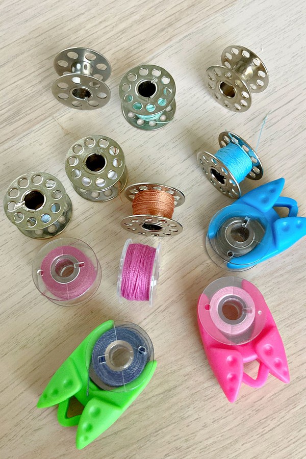 vibrant bobbin holder filled with a selection of colorful bobbins. Each bobbin displays a spectrum of thread colors