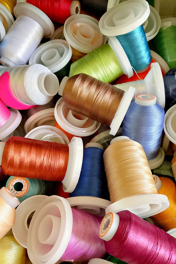 The spools showcase a range of hues highlighting the diversity and versatility of sewing thread options
