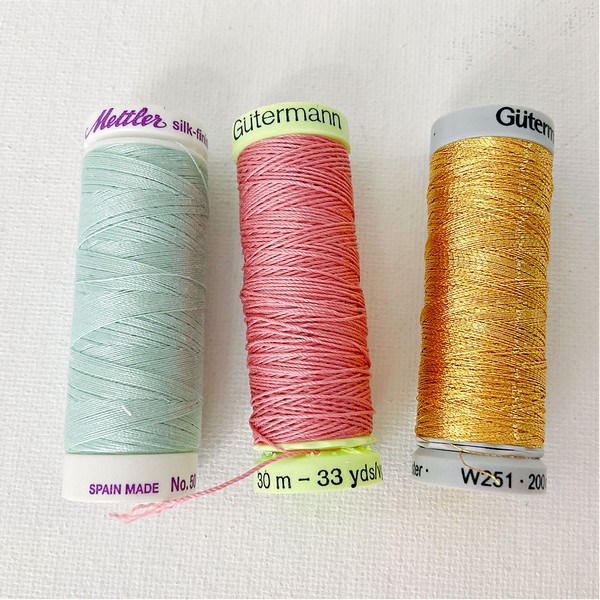 Assortment of different types of sewing threads, featuring a range of colors and materials suitable for various crafting and sewing projects
