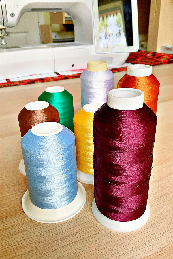 Image displaying an array of threads in diverse colors and types, suitable for various sewing and crafting endeavors