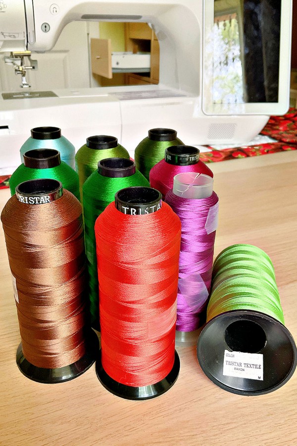 Image depicting a collection of threads in a spectrum of colors and various types, ideal for a wide range of sewing and crafting projects