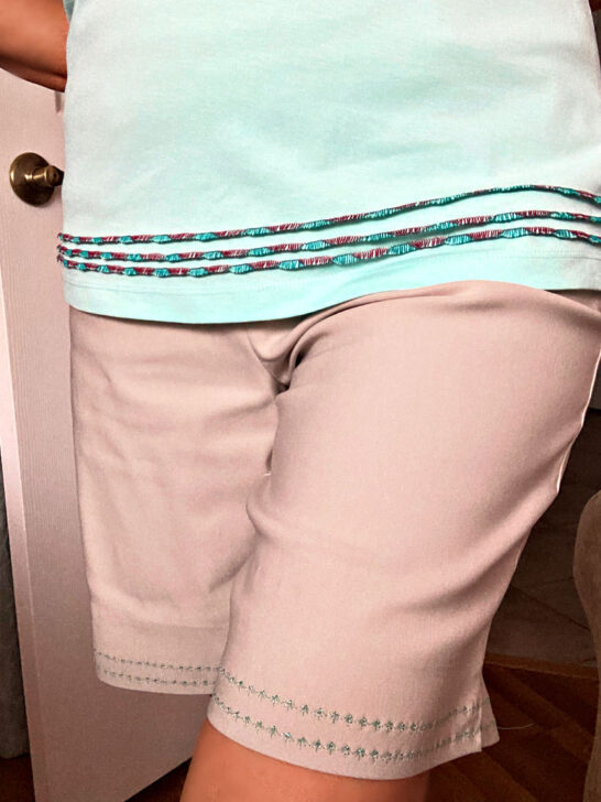 i am wearing shorts that feature decorative stitches with metallic thread