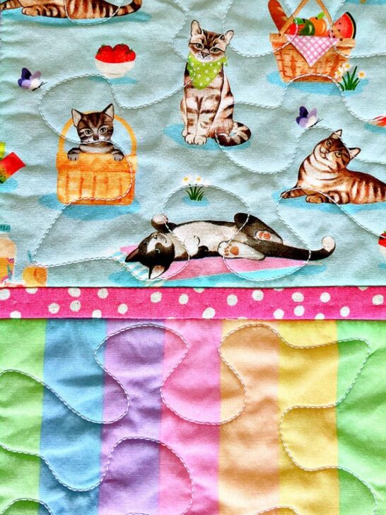Close-up image showcasing intricate quilting patterns on a vibrant patchwork quilt. The quilting stitches, skillfully executed with fine white cotton thread, form a delicate and textured design, enhancing the overall craftsmanship of the quilt