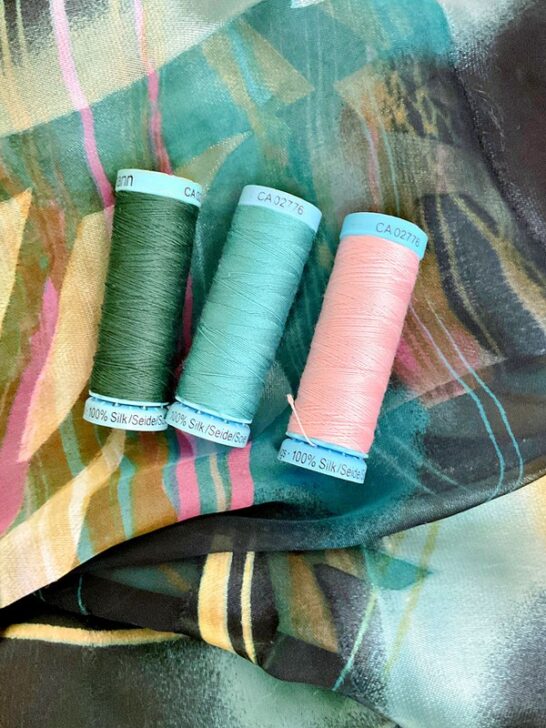 Close-up image of silk threads delicately arranged on a luxurious silk fabric background