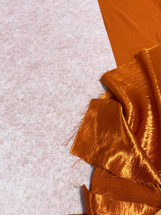 applied Pellon fusible interfacing on orange polyester satin