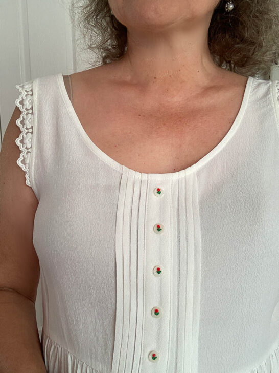 me wearing a white blouse with floral button embroidery