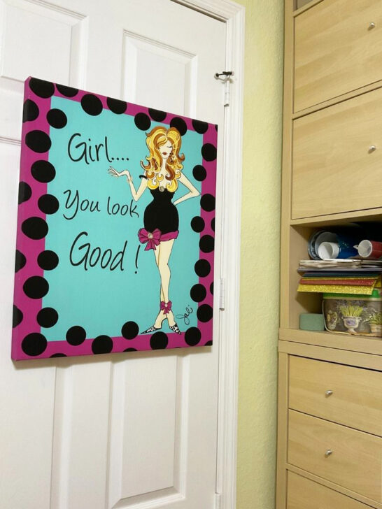 A door in a sewing room featuring a sign that reads, Girl, you are good, promoting positivity and encouragement.