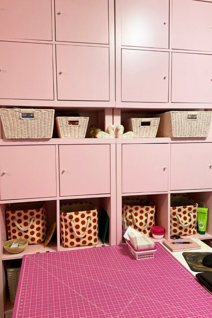 A vibrant pink craft room with lots of storage room decor for creative projects