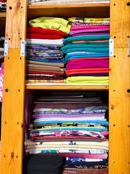 A wooden cabinet with colorful fabrics