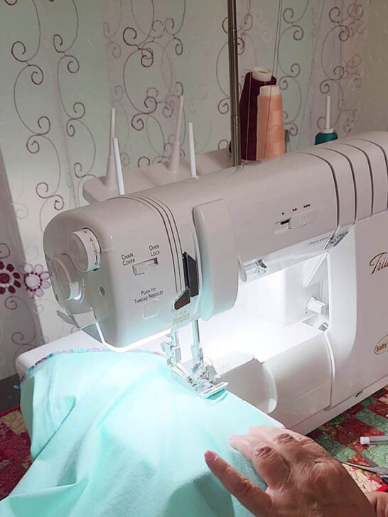 Place the folded edge under the serger foot