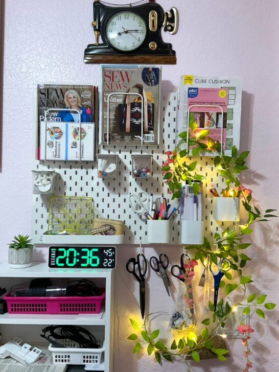 Wall decor in a sewing room showcasing a clock, scissors, and assorted sewing tools and materials