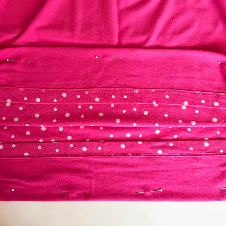 securing the new hemline with pins