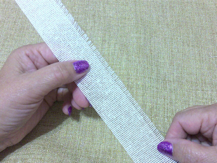 A person holding a piece of buckram fabric