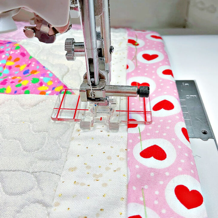 Stitch along one of the long seams where the quilt block meets the border strips. This step ensures everything stays in place during further sewing.
