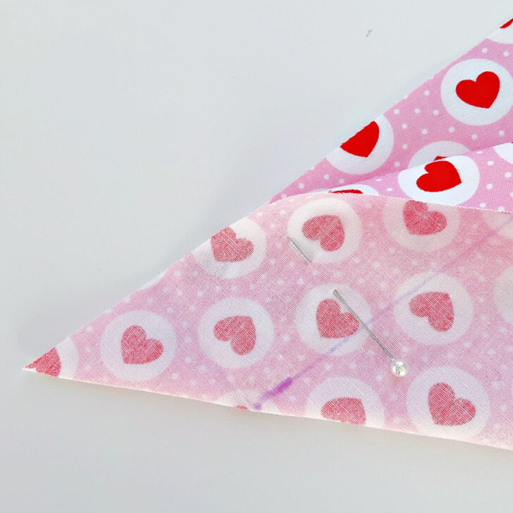 Start preparing the backing fabric by folding the corner diagonally so that the raw edges meet