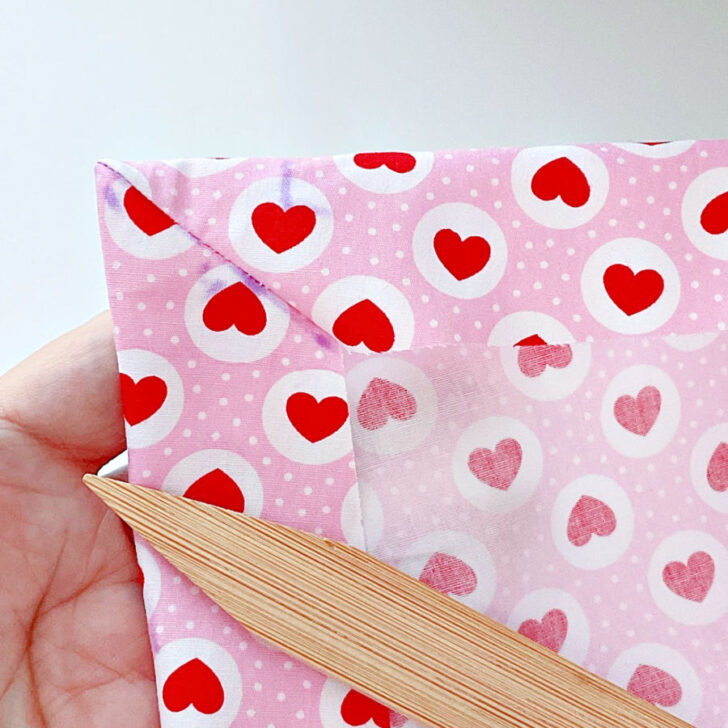 Use a corner-turning tool or a similar object to push out the fabric and shape the corners into neat, sharp points