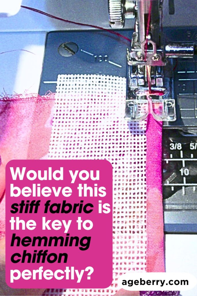 A sewing machine stitching a piece of pink chiffon fabric with a strip of buckram fabric used as a guide. The presser foot and needle are clearly visible, demonstrating a technique to hem chiffon perfectly.