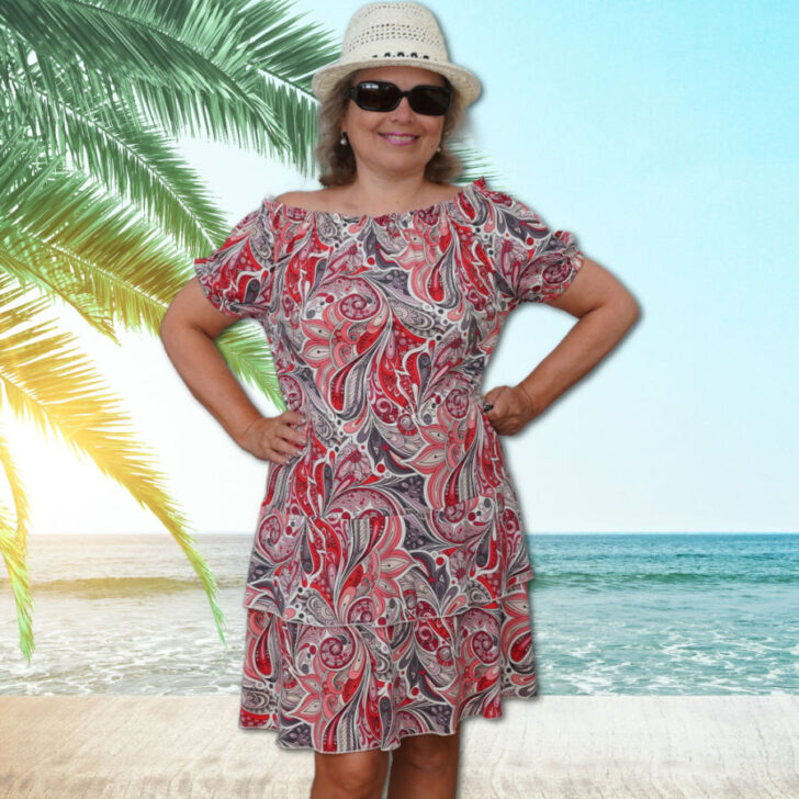 A vibrant off-the-shoulder dress with a red and gray paisley pattern, showcased in a fashion sewing tutorial for creating breezy summer outfits.