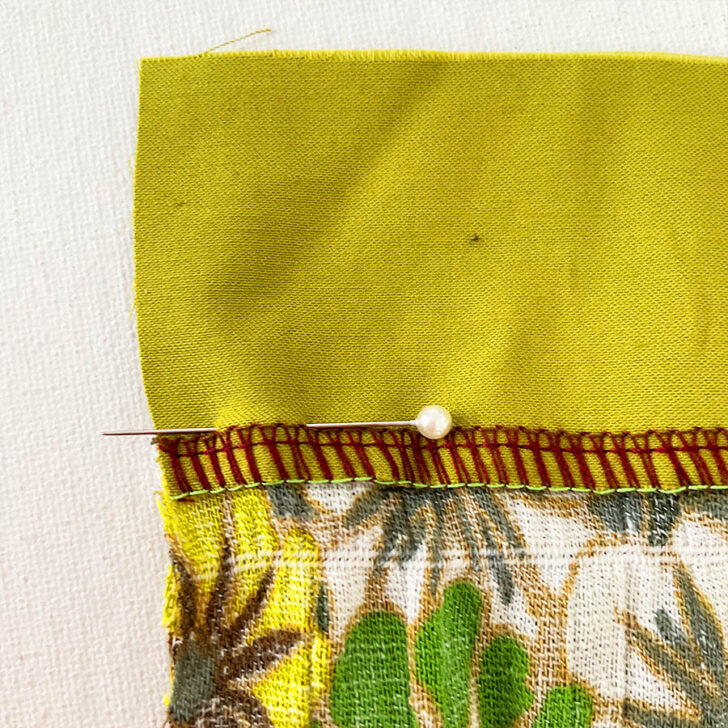 Continue pinning. Push the pin back through the first fabric, ensuring it is inserted precisely into the seam line.