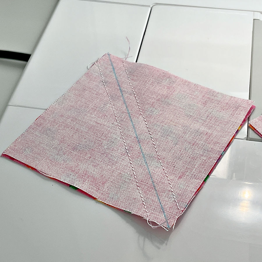 The image shows the first step when making half square triangles used in quilting