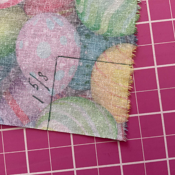 Square marking on a corner of the backing fabric in preparation for sewing a mitered corner