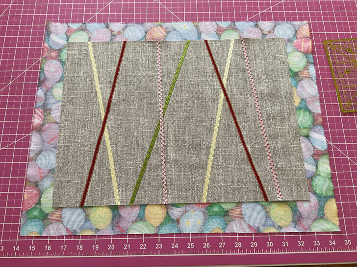 Image shows the finished base placemat on top of the backing fabric before stitching