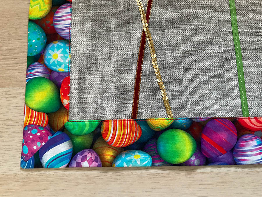Image shows a close up of a corner of the Easter table runner after the final press
