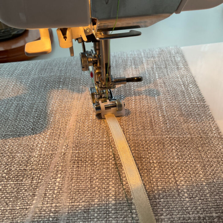 Image of the sequin ribbon foot installed on a sewing machine and sewing a decorative ribbon