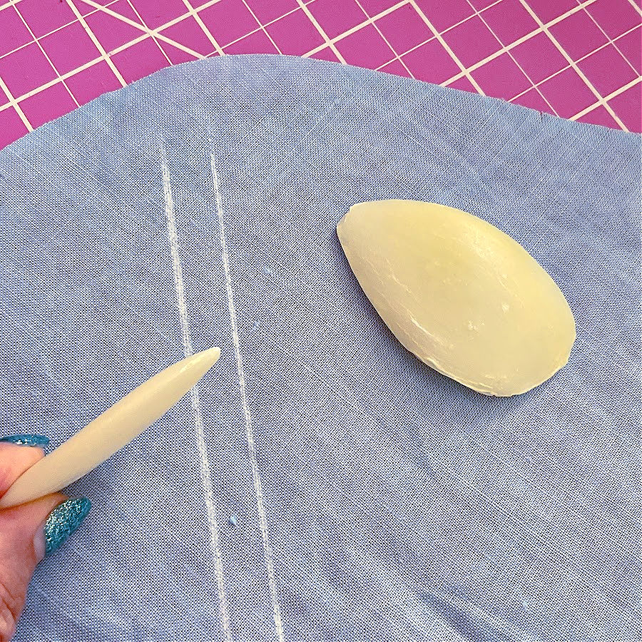 Slivers of soap used to mark lines on a piece of fabric. A cutting mat in the background