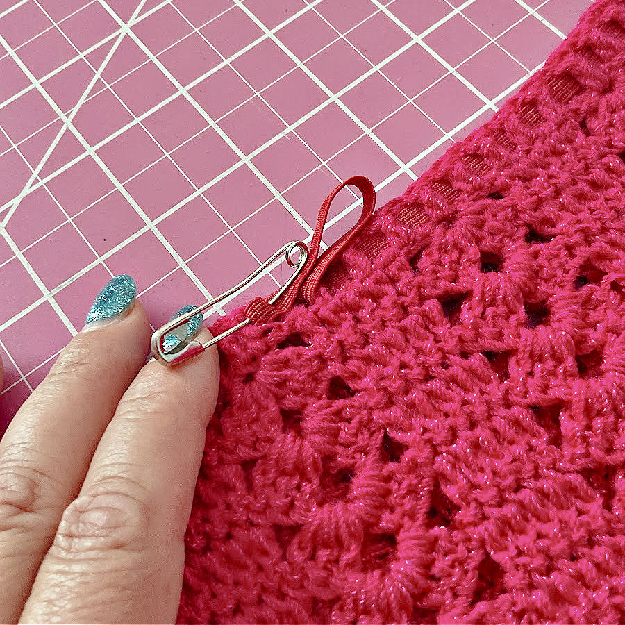 A safety pin while being used to thread elastic through a crocheted item