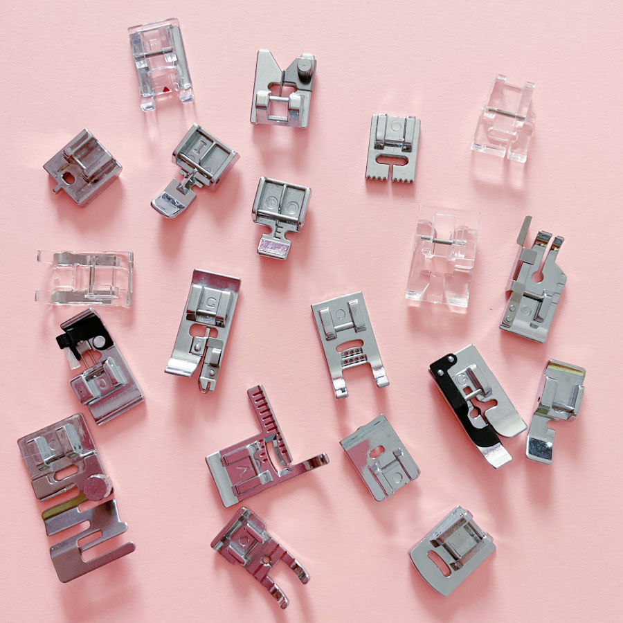 Various sewing machine presser feet spread on a table for display purpose