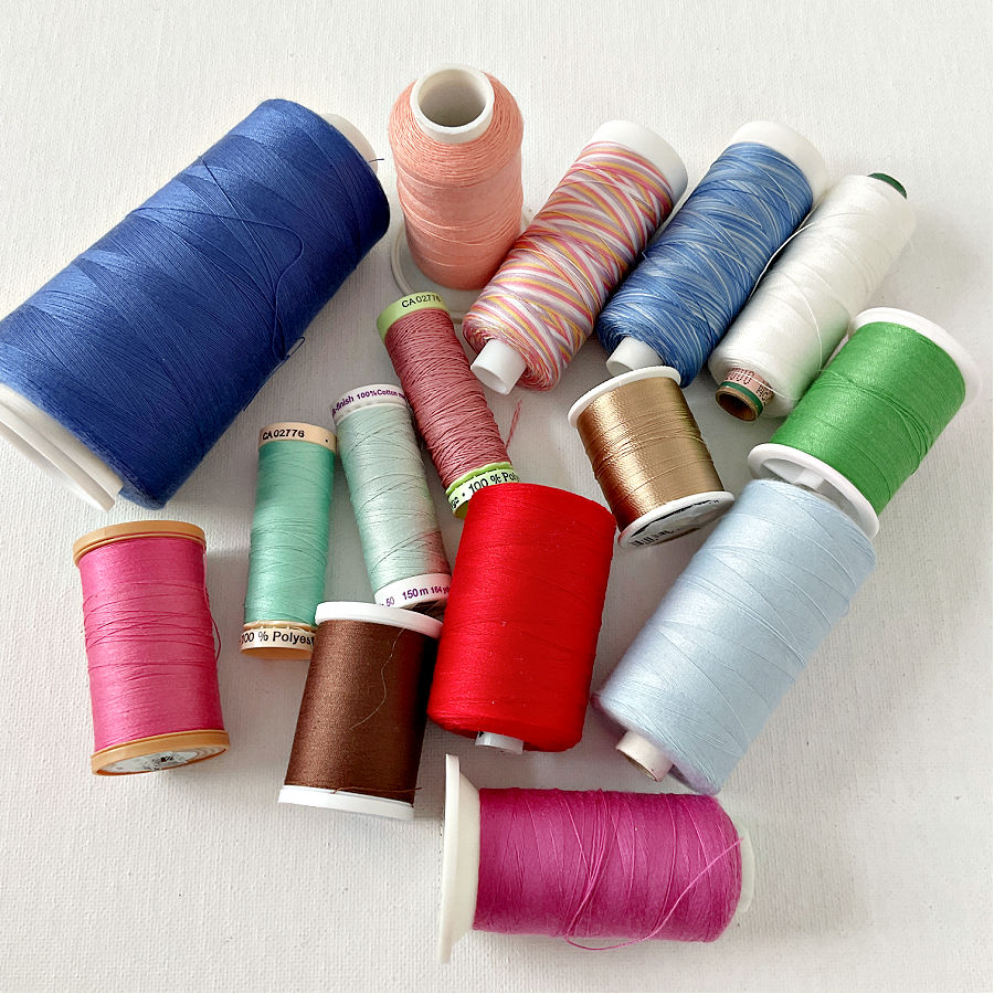 A collection of spools and cones of thread of various colors and purposes