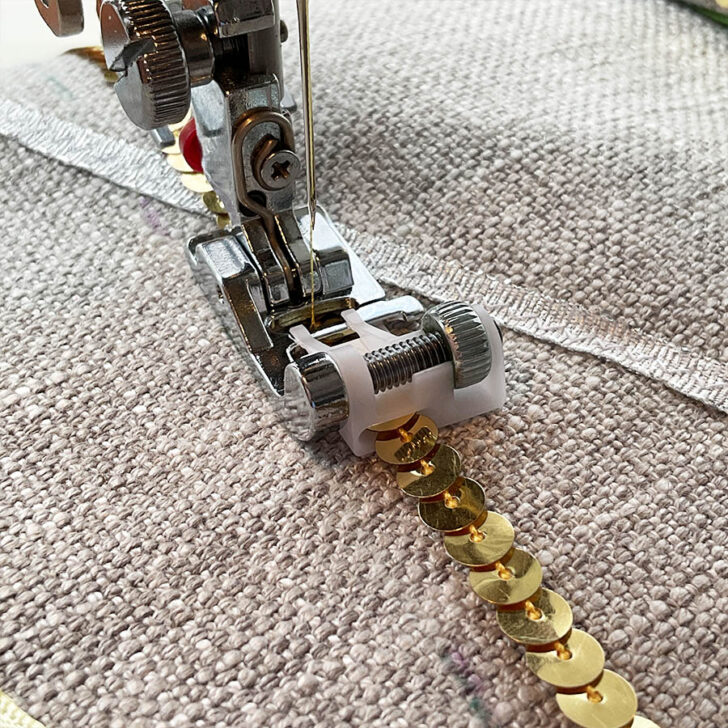 A sequin ribbon prfesser foot shown while sewing a sequin ribbon