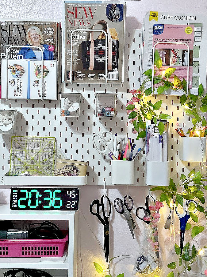 A pegboard with accessories used for organizing scissors, thread spools, rotary cutters, and rulers
