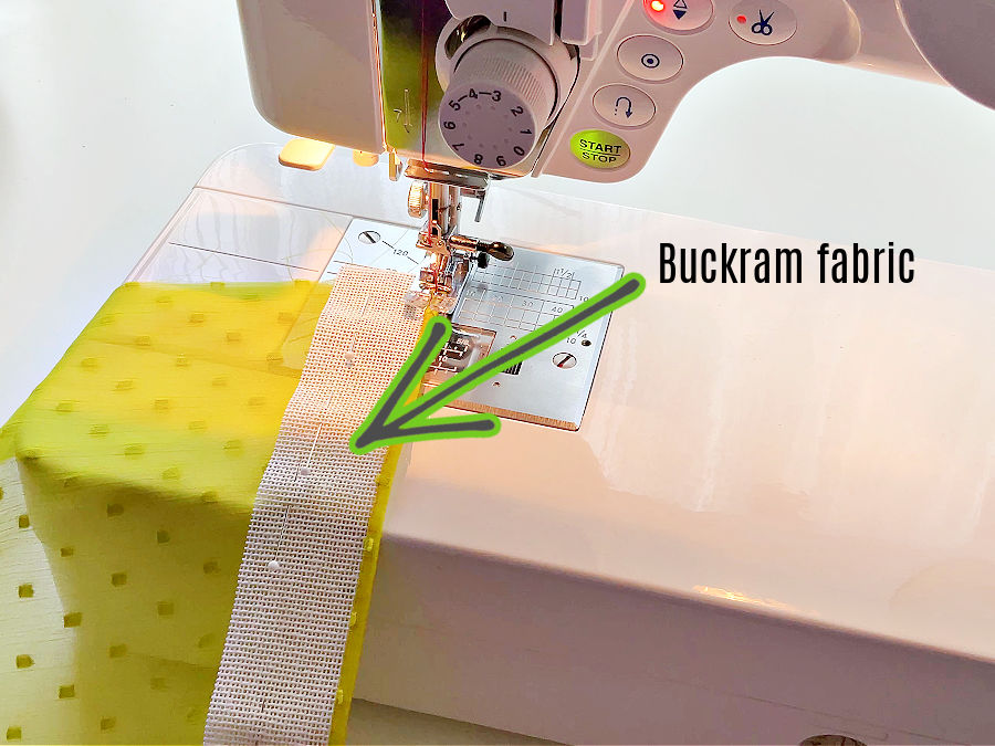 A piece of lightweight fabric being hemmed on a sewing machine with the use of buckram
