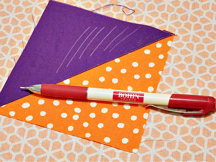 Bohin chalk pencil on a finished half square triangle with some pencil marks on it